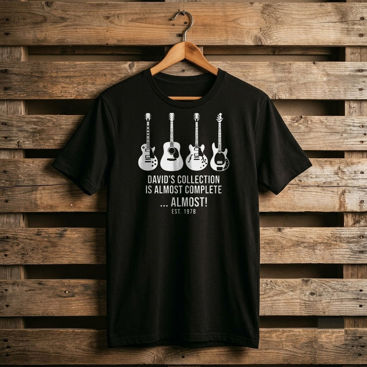 Black shirt with a row of four white guitars and David's Collection Is Almost Complete ... Almost! EST 1978