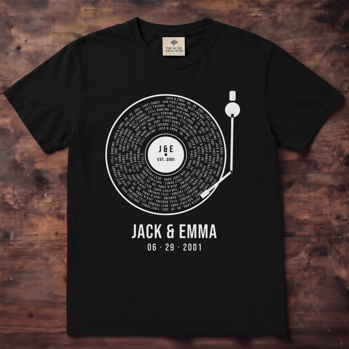 Black shirt with a white vinyl record, Jack and Emma and 06 29 2001 spiraling in the grooves, J & E on the label