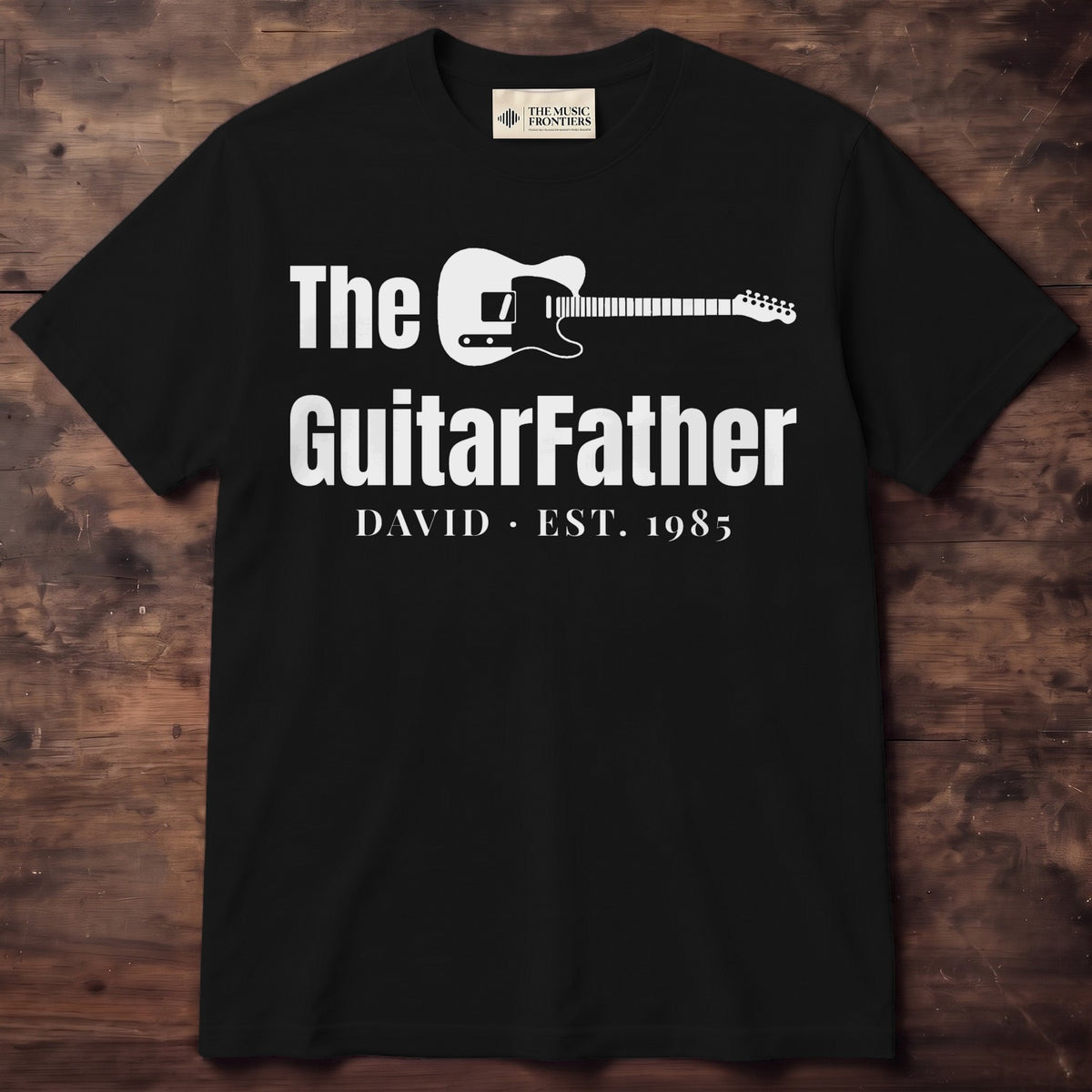 Black tee reading The GuitarFather with a guitar lying across the top line and DAVID EST. 1985 underneath