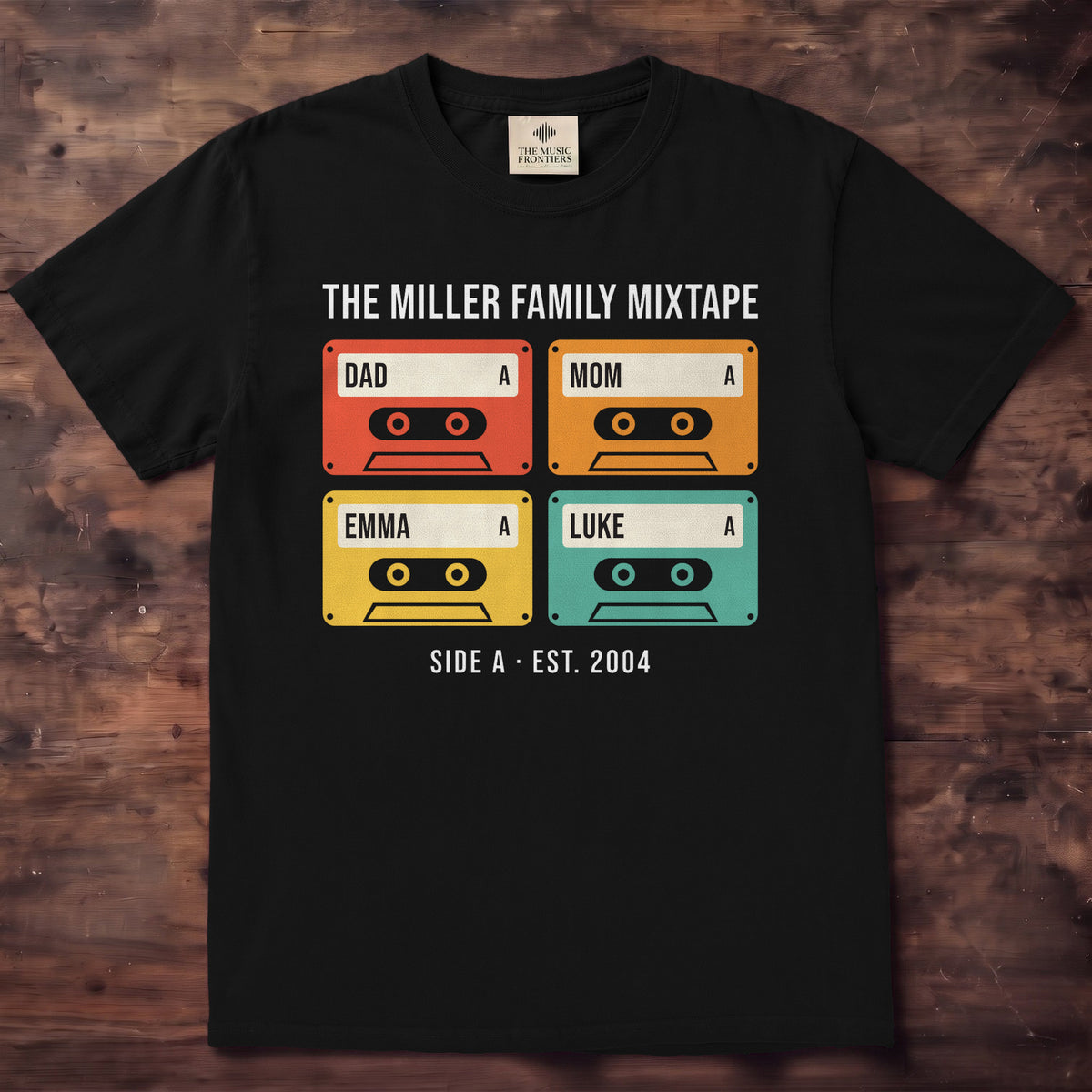 Black shirt with a grid of colorful cassette tapes labeled Dad, Mom, Emma and Luke under The Miller Family Mixtape