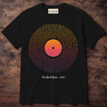 Black tee with lines of words filling a vinyl record in sunset gold, coral and purple, with a short line underneath
