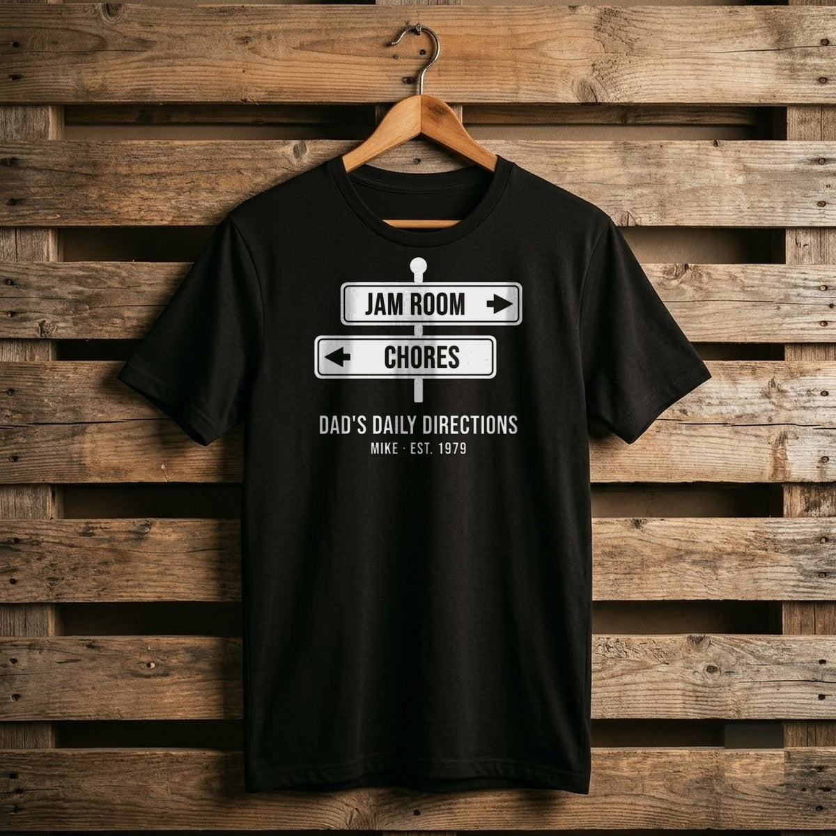 Black shirt with two white street signs, JAM ROOM and CHORES, under Dad's Daily Directions