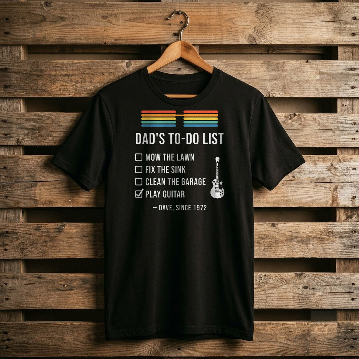 Black shirt with Dad's To-Do List: three unchecked chores and a checked box for Play Guitar